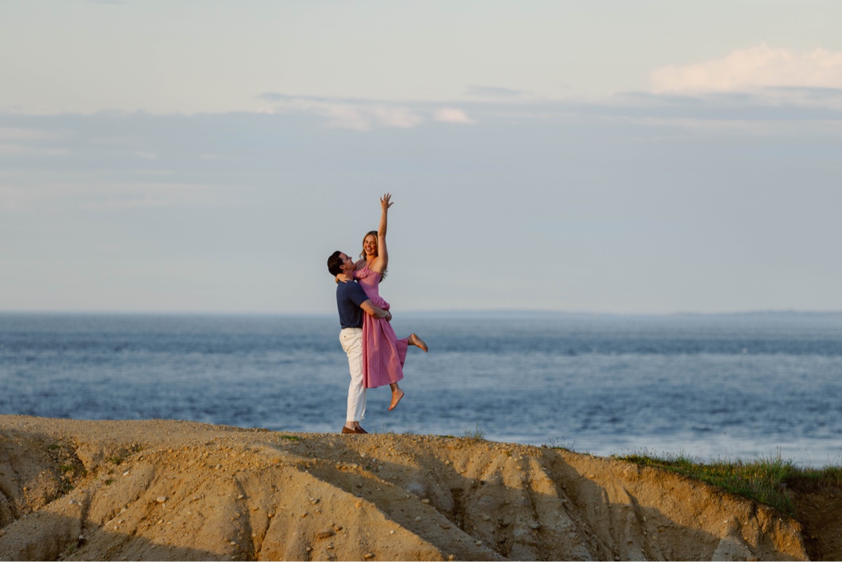 Newly engaged couple celebrating on a bluff above the ocean on Long Island