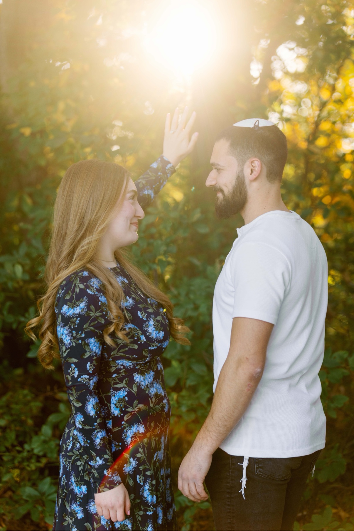 Surprise proposal at Twin Lakes Preserve, Wantagh, New York — a couple face to face with the late sun flaring behind them just after she said yes