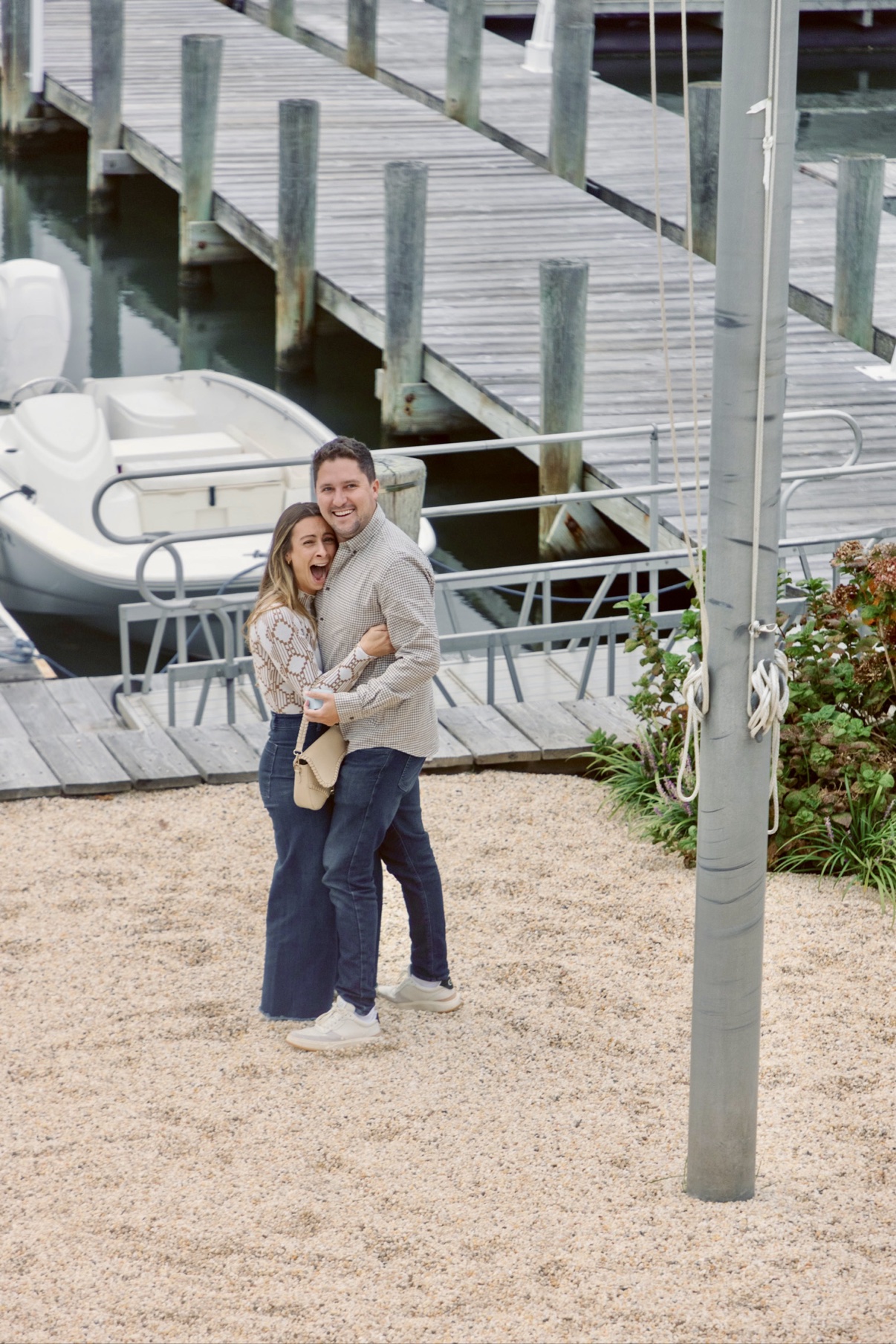 A just-engaged couple hugging by the docks in Sag Harbor, Long Island — her joyful reaction after saying yes