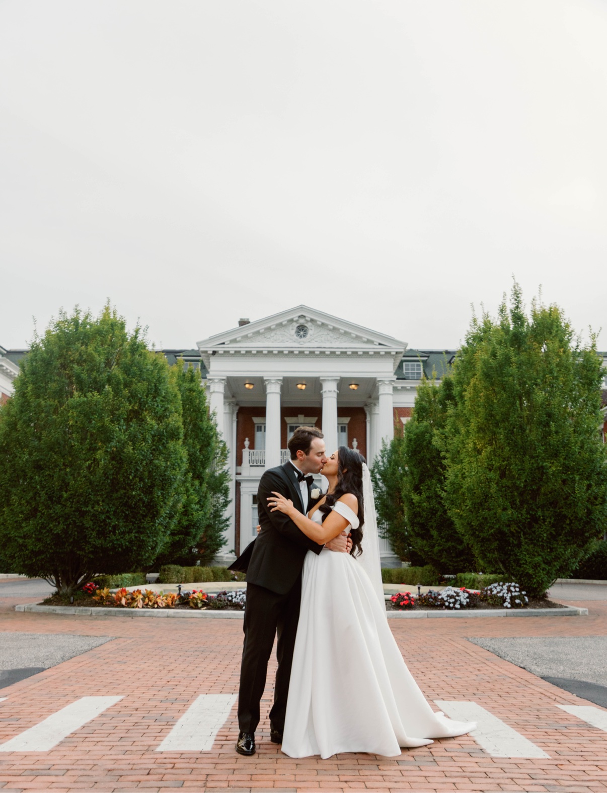 Newlyweds standing together before Bourne Mansion