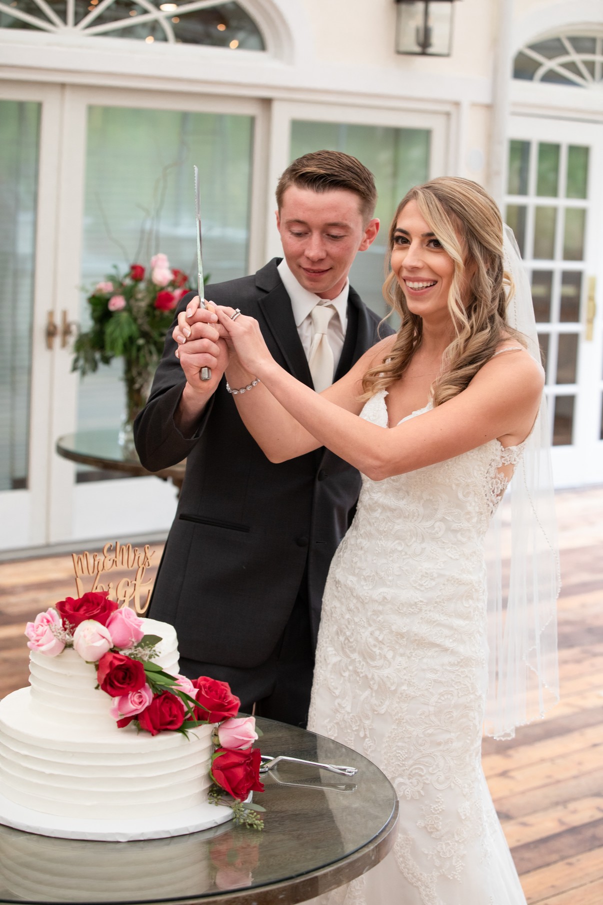 Bride and groom holding the knife together as they cut their wedding cake at The Vineyards at Aquebogue — Long Island wedding photographer