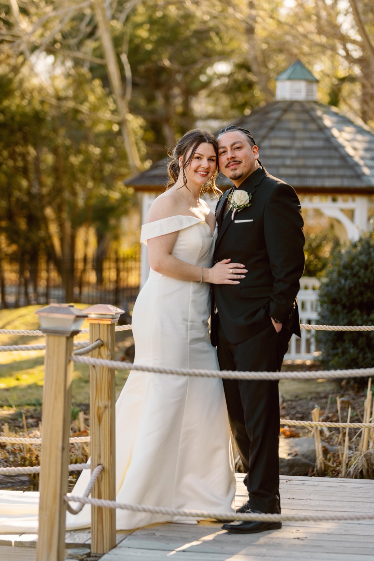 Newlyweds embracing on the bridge by the gazebo at a Long Island estate wedding — Long Island wedding photographer
