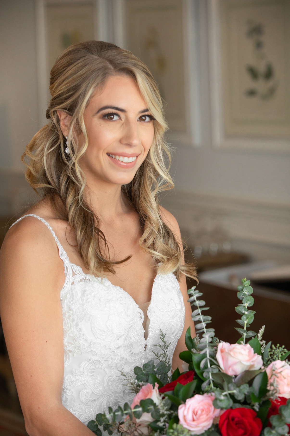 Smiling blonde bride holding a pink and red rose bouquet at The Vineyards at Aquebogue — Long Island wedding photographer