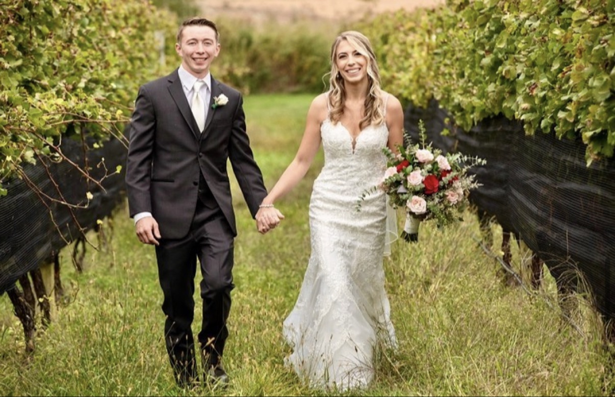 Newlyweds walking together beside vineyard rows at a North Fork vineyard wedding — Long Island wedding photographer